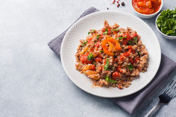 Buckwheat porridge with canned tomato and pepper. Copy space