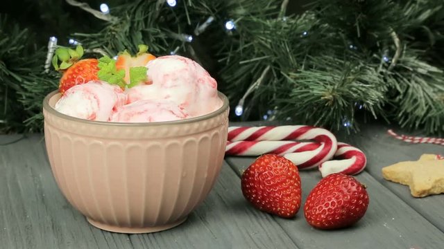 Ice cream for the new year. A nice composition of ice cream and strawberries on the background of a Christmas tree