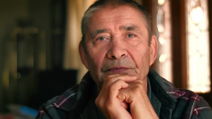 Serious elderly man thinking, looking at camera, closeup. 4K UHD.