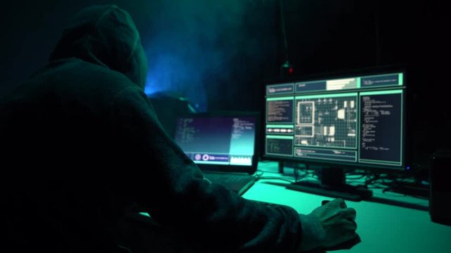 Wanted hackers coding virus ransomware using laptops and computers in the basement. Cyber attack, system breaking and malware.