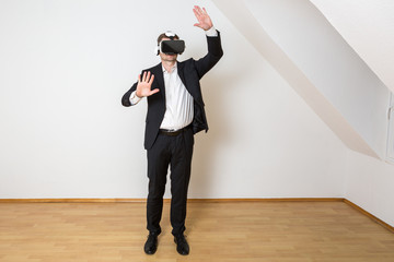 Mann bewegt sich im leeren, weißen Raum mit Laminat Boden und betrachtet die virtuelle Einrichtung...
