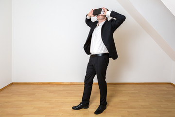 Mann nutzt die Vorteile der Digitalisierung. Er schaut sich seine virtuelle neue Wohnung an.