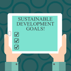Writing note showing Sustainable Development Goals. Business photo showcasing Unite Nations Global vision for huanalysisity Hu analysis Hand Holding Tablet Smartphone Display Unit photo