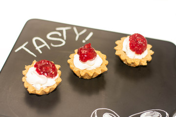 Three cheese cakes with raspberry dressing on the top