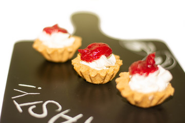 Three cheese cakes with raspberry dressing on the top