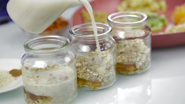 Woman's hands putting layers fruits in a transparent bowl. cooking delicious home made desserts