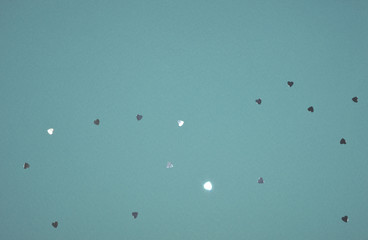 Silver glitter hearts on blue background in vintage colors