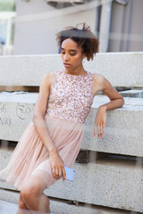 Street fashion. Portrait of an African young woman in pink dress