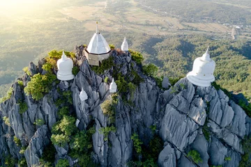 Fototapeten Spectacular aerial view of floating pagodas on the mountain cliff at Wat Chaloem Phra Kiat in Chae Hom District, Lampang province, Thailand. © zephyr_p