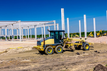 Grader is leveling ground at construction site