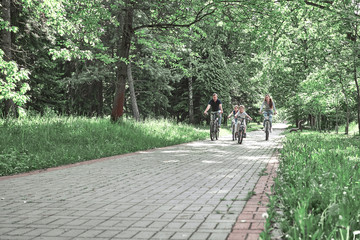 Fototapeta premium family with two children on a bike ride in the city Park