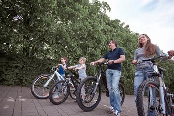 Fototapeta premium happy family on a bike ride in the city Park