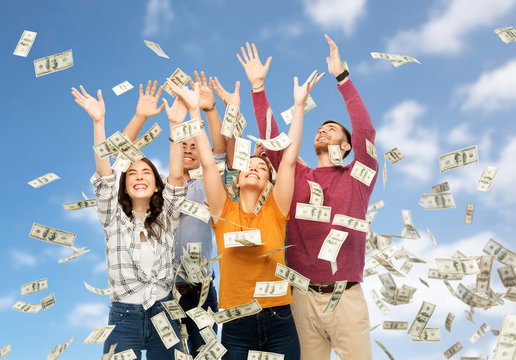 Finance, Wealth And People Concept - Group Of Happy Friends Picking Money Falling From Up Above Over Blue Sky And Clouds Background