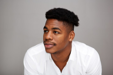 Close up young black man looking away against gray background
