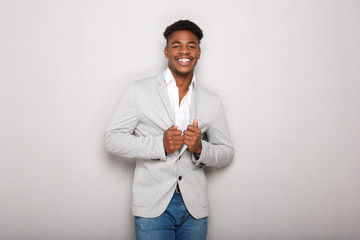 cool young african american businessman smiling against gray background