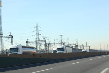 highway with trucks and eleitric trellis on the background