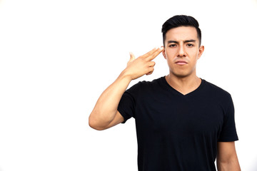 Fototapeta premium Portrait of a young latin handsome man with two fingers to his head