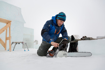 Worker examines the condition of the chainsaw