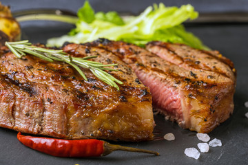 A cutted ribeye steak on a black stone slab