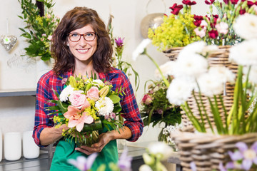 Lächelnde Floristin präsentiert stolz einen frisch gebundenen Blumenstrauß zum Valentinstag