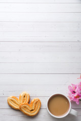Valentine's day Breakfast concept. Cup of coffee and a cookies hearts on a white table. copy space, flat lay.