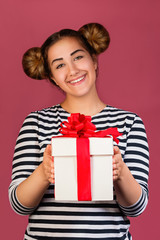 Picture of hipster girl with funny hairstyle with gift box on pink background