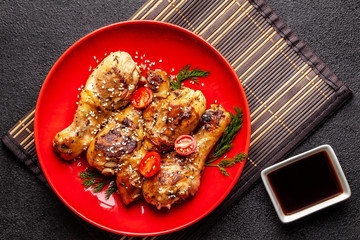 The concept of Japanese and Chinese cuisine. Chicken fried legs with hot pepper, sesame, chuka salad, Chinese peas on black table. Asian dish. top view, flat lay