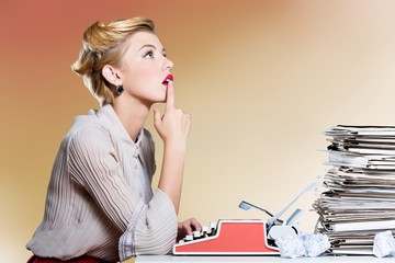 Attractive young woman working on vintage typewriter