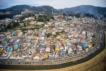 Aerial view of colorful houses of Ooty city on Nilgiri mountains at Udhagamandalam, Tamil Nadu, India. Urban landscape.