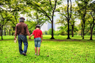 Obraz premium father and son walking together in park
