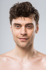 handsome young smiling man isolated on grey