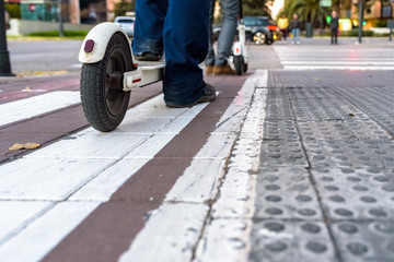 White electric scooters waiting in a bike lane.