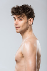 Naklejka premium portrait of handsome young brunette man isolated on grey