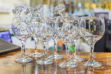 Multiple glassware on the table. Empty clean glass for vine and short drinks at the bar. Selective focus