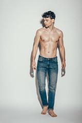 Fototapeta premium sexy shirtless muscular macho in jeans posing on grey