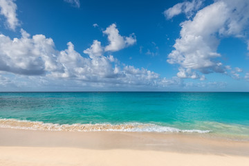 Beautiful marine view on tropical caribbean beach with white sand and turquoise water under blue sky and clouds at sunny day as natural background