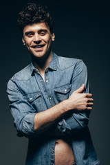 handsome laughing man posing in denim clothes isolated on grey