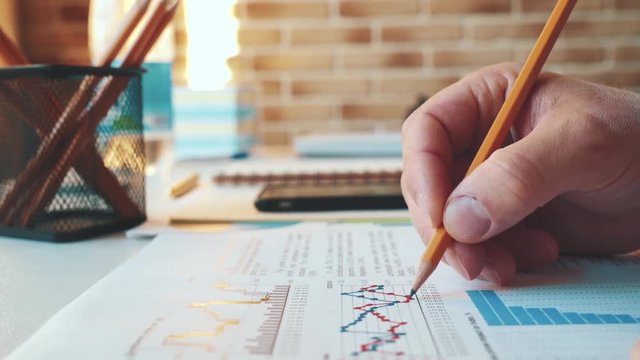 Businessman checking financial report and charts in the office at the workplace. Close view and very smooth dolly shot 4K video