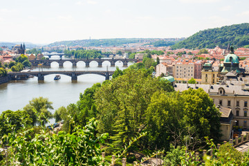 Fototapeta na wymiar Scenic view of bridges on the Vltava river and of the historical center of Prague: buildings and landmarks of old town with red rooftops