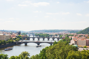 Scenic view of bridges on the Vltava river and of the historical center of Prague: buildings and landmarks of old town with red rooftops