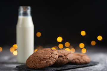A glass of milk and chocolate cookies with beautiful lights
