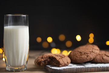 A glass of milk and chocolate cookies, with beautiful lights and Concept, copy Space