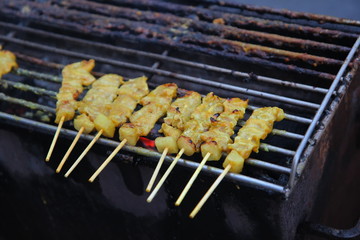Grillled barbecue pork satay skewers on charcoal grill stove in street food market. Pork. Grilled spices pork on Charcoal stove 