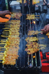 Grillled barbecue pork satay skewers on charcoal grill stove in street food market. Pork. Grilled spices pork on Charcoal stove 