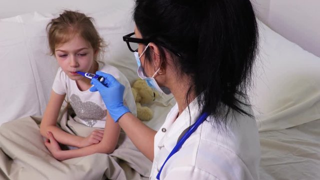 Woman doctor measure girl body temperature