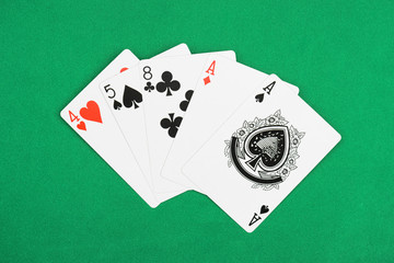 top view of green poker table and unfolded playing cards with different suits