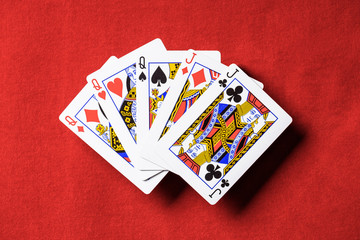 top view of red poker table and unfolded playing cards combination with different suits