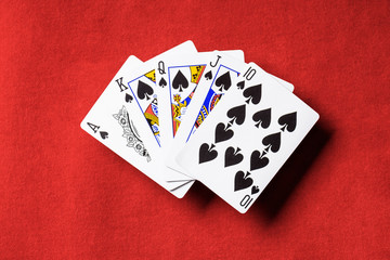 top view of red poker table and unfolded playing cards with spades suit