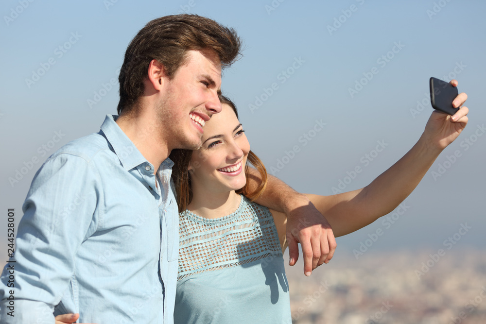 Wall mural Couple taking selfies in a city outskirts