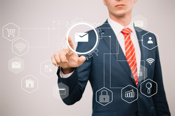 cropped view of businessman in suit pointing at email icons isolated on grey